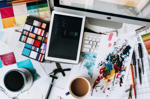 Messy desk with digital device, coffee, art tools