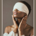 Beautiful black woman with blindfold on, coffee and cream backdrop