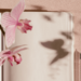 Open blank note book with a pen and butterfly flowers floating off the page