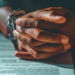 Clenched hands with chain around them over the Terms and Conditions.