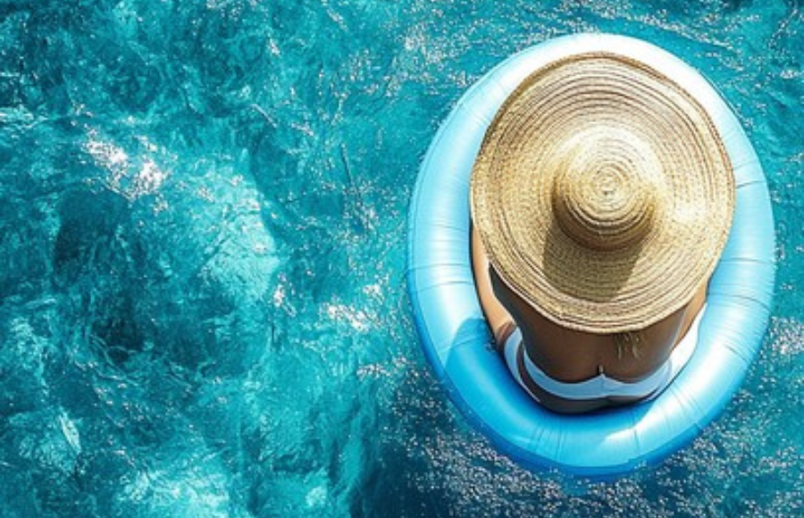 Woman with large hat covering most of her body, in a crystal clear body of water