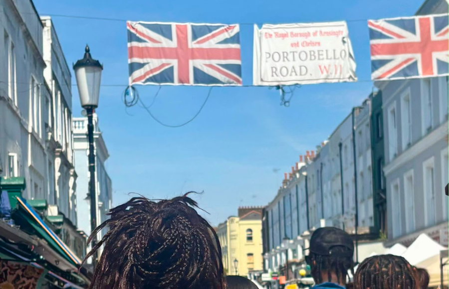 Photo - back of IreneB kids and fam walking under the Portobello Road banner with two Union Jack flags.